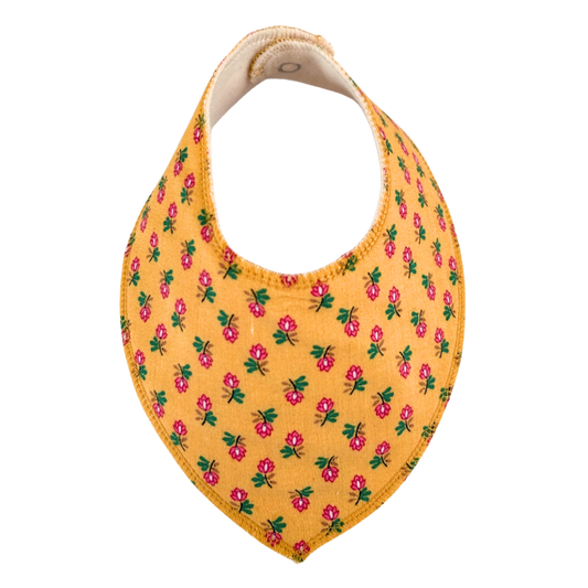 Dregglis sydd i gult tyg med blommr i rosa och grönt.