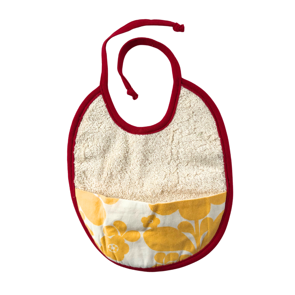 Haklapp i ekologisk bomull med ficka i av återbrukat tyg med gula blommor på vitt botten och rött kantband