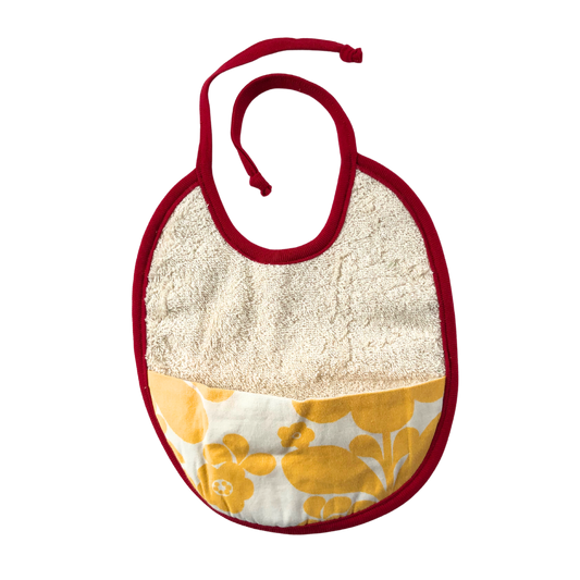 Haklapp i ekologisk bomull med ficka i av återbrukat tyg med gula blommor på vitt botten och rött kantband